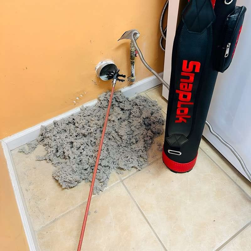 Professional dryer vent cleaning removes a large pile of lint and debris from a home vent
